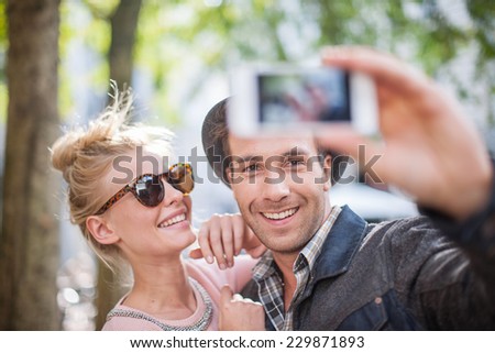 Young trendy couple in the city making a Selfie with a smartphone
