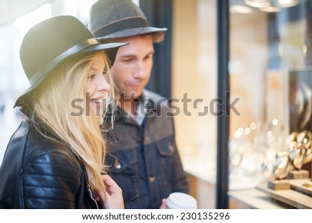 in the city a young trendy couple looking at watches in a showcase
