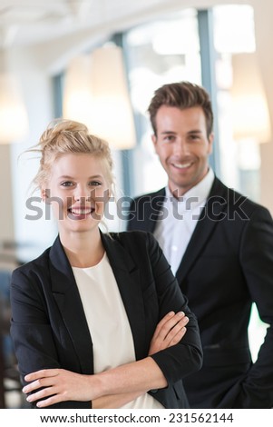 portrait of a business team at office looking at camera, executive woman at foreground and man at the background