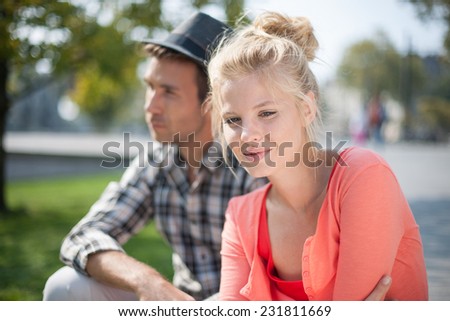 portrait of a modern couple in the city, man wears a hat, woman wears sunglasses