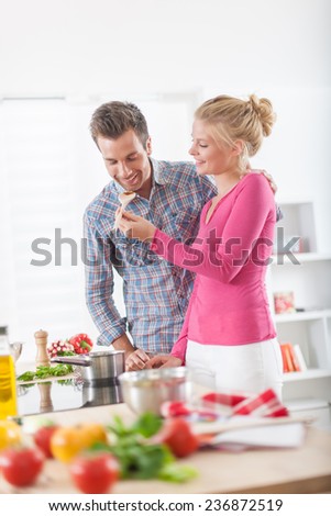 Handsome couple cooking on a cook top at home, vegetables on the work plan