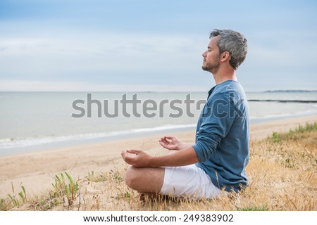 He is meditating with his hands turn up to the sky.