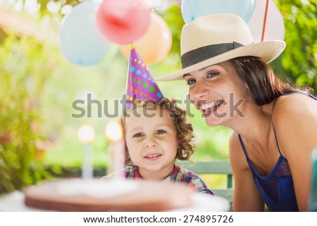 Garden party for the birthday\'s little girl with mum, Girl waiting to blow her candles