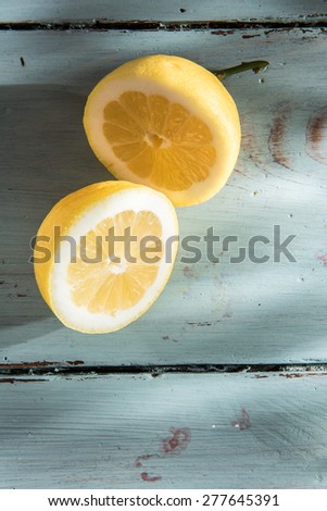 a yellow lemon cut in half on a wooden background