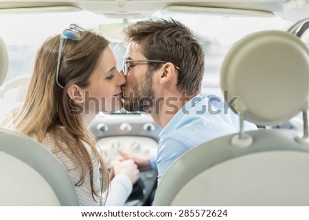 rear view, a lovely couple kissing in a car
