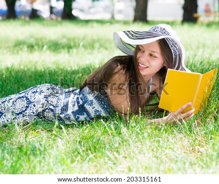 young woman reads what is on the grass