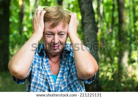 an elderly woman in despair in the forest