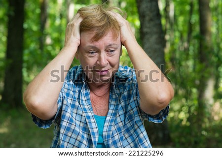 an elderly woman in despair in the forest