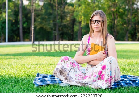 student on the grass with a book