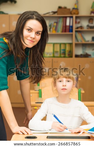 Teacher helping student in the class with the task