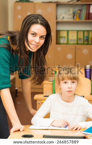 Teacher helping student in the class with the task