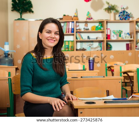 teacher in classroom near desks