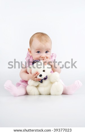 Little girl with plushy cuddle-bear and his ear in mouth,,on white background.