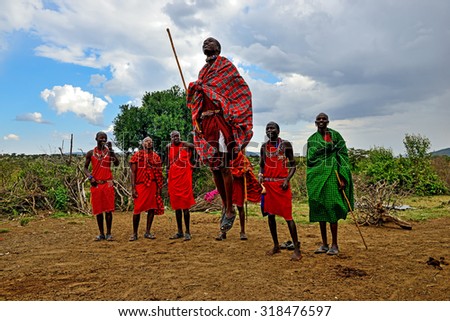 MASAI MARA, KENYA - August 13: Masai warriors dancing traditional jumps as cultural ceremony. As well as women sing and dance. Masai Mara National Park, August 13, 2015 in Kenya