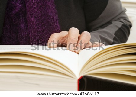 Never too old to learn - Hands of old woman reading book