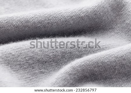Detail of woven woolen design texture. Fabric grey background