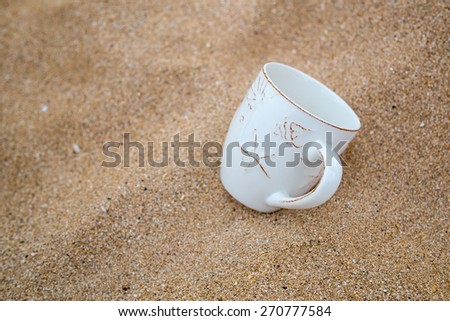 Concept for relaxation, coffee mug in sand