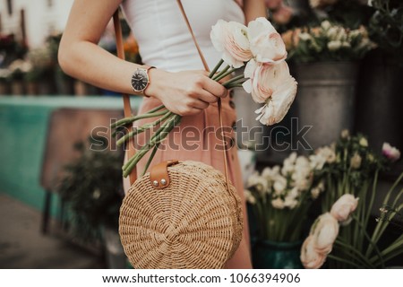 Blogger girl holding a bunch of flowers at the flower market. Blogging concept.