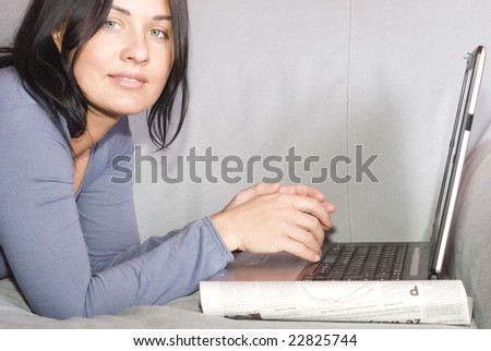 Pretty woman relaxing with laptop on couch