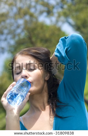 Portrait of young girl holding bottle of water in hand
