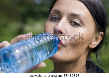 Portrait of young girl holding bottle of water in hand