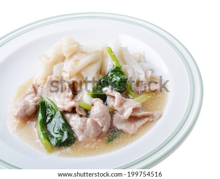 Noodle with pork and kale topping served in white bowl