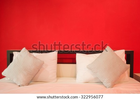 Simple red bedroom with bed and nightstand.copy space