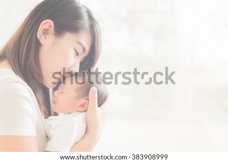 Happy mother holding adorable child baby boy