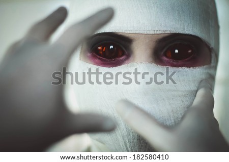 Hands in surgical gloves are drawn to face, close-up portrait