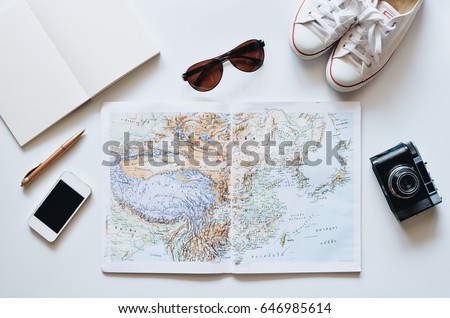 top view of map,smart phone,vintage camera and sunglasses on white background,travel concept