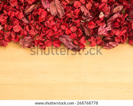 Frame of Red Dried flowers and leaf on a wooden plates background ( Space and composition for text)