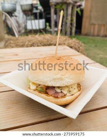 Home made burger with pork , bacon , cheese ,on wooden box