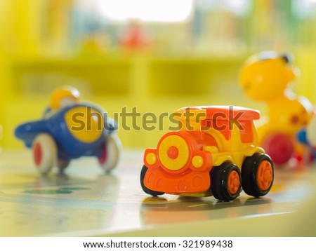children toys - Orange plastic toy engine train and another toy  on a table