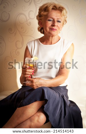 Beautiful senior woman holding an alcoholic drink
