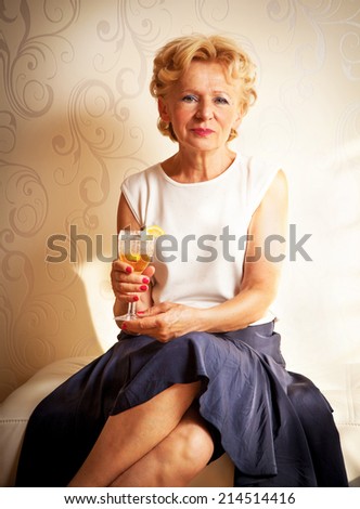 Beautiful senior woman holding an alcoholic drink