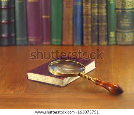 old book with leather cover and vintage magnifying glass