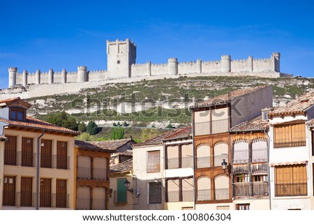 Medieval houses of the Plaza del Coso in Penafiel, with the castle and a blue sky as background. Valladolid, Spain