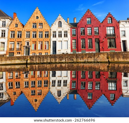 Bruges canals: Spinolarei reflected in the canal in a sunny day. Belgium