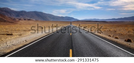 A Desert Highway And Distant Mountains In Death Valley National Park, California, USA