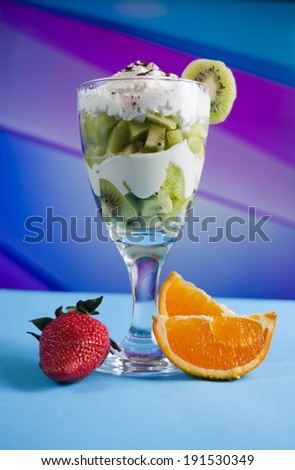 kiwi cocktail with orange, strawberry and whipped cream