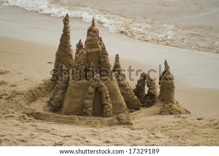 Intricate sand castle by the sea with some waves