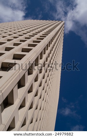 Detail of office block with patterns created by windows against blue sky