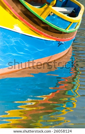 Close up of a traditional Mata fishing boat Luzzu with reflection on rippled water