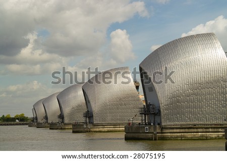 Detail of Thames Barrier on river Thames, against blue sky with clouds