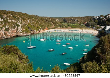 Beach on a bay with aqua water, several boats. Suitable for the summer holiday concept
