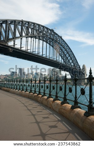 Sydney, Australia - 18 February 2011 : Sydney Harbour Bridge and metal fence against blue sky with some white clouds