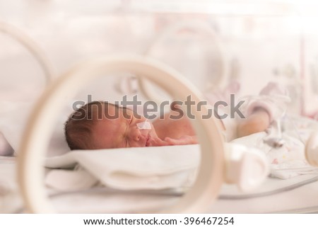 Premature newborn  baby girl in the hospital incubator after c-section in 33 week