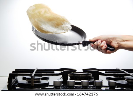 Frying pan with flying pancake