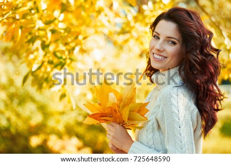 Autumn woman in autumn park. Warm sunny weather. Fall concept