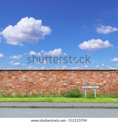 Red Brick Wall with a Main Street Sign and Sidewalk